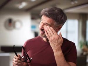 Mna living with keratoconus rubbing his eyes